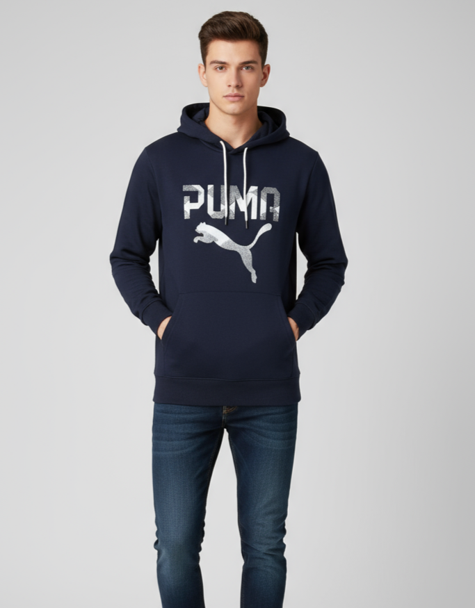 Man wearing a navy Puma hoodie and jeans on a light gray background