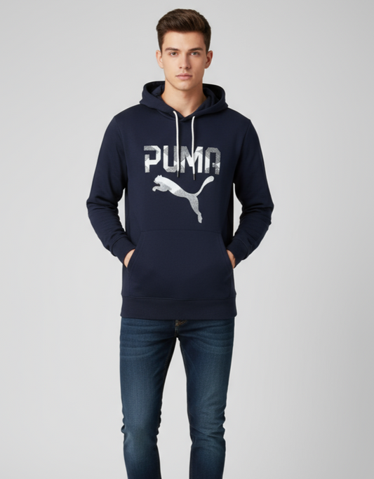 Man wearing a navy Puma hoodie and jeans on a light gray background