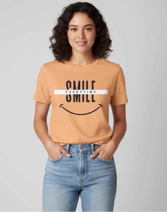Woman wearing a peach t-shirt with 'Smile Everytime' text and smiley face design on a plain background