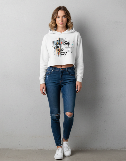 Woman wearing a white hoodie with graphic design and blue jeans on a gray background